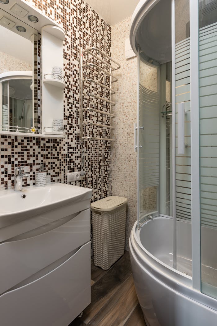 Stylish bathroom featuring mosaic tiles, round shower, and modern fixtures.